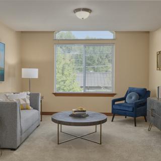 A cozy living room featuring a sofa, armchair, and coffee table with soft lighting.