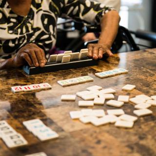 A person playing a game of dominoes at a table.