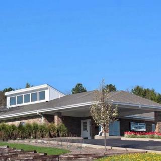 A modern building with a landscaped exterior under a clear blue sky.