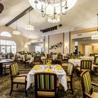 Elegant dining area with chandeliers and neatly arranged tables and chairs.