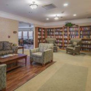 A cozy library reading room with bookshelves and comfortable seating.