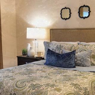 Cozy bedroom with a well-decorated bed and stylish lighting.