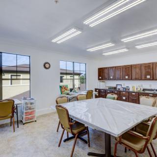 A bright kitchen and dining area with a large table, chairs, and ample cabinet space.