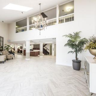 A bright and spacious modern lobby with elegant furnishings and decorative plants.