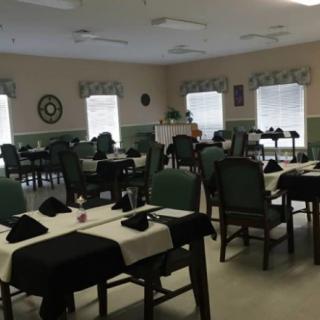 A neatly arranged dining area with tables and chairs set for guests.