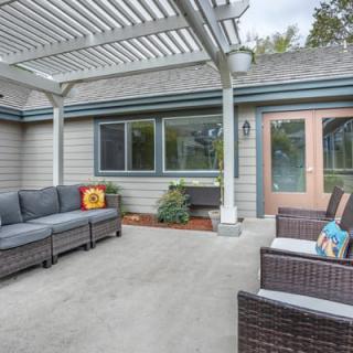 A modern patio with outdoor seating and a pergola.