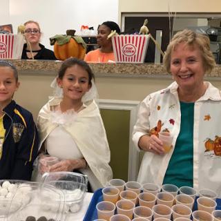 A fun community event featuring children in costumes, enjoying treats together.