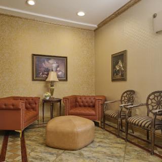 A cozy waiting area featuring elegant furniture, artwork, and a warm color palette.