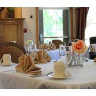 An elegantly set dining table with folded napkins, glasses, and a floral centerpiece.