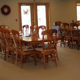 A spacious dining area with wooden chairs and a large table.