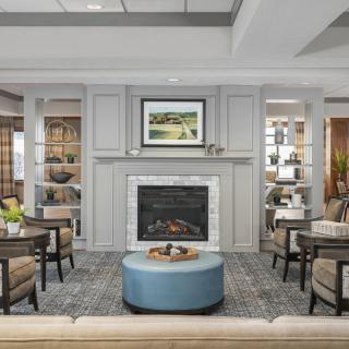 A contemporary living room with a fireplace, comfortable seating, and tasteful decor.