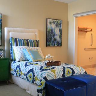 A modern bedroom with colorful bedding and stylish decor.