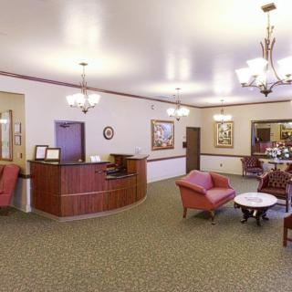 A spacious lobby with a reception desk, seating area, and elegant lighting fixtures.