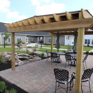 A beautifully landscaped patio with a pergola and outdoor seating area.
