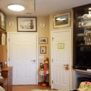 A cozy interior view showcasing decorated walls with various pictures and two white doors.