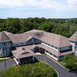 Aerial view of a large residential building surrounded by lush greenery.