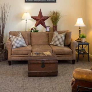 A cozy living room with a rustic theme, featuring a comfortable sofa, decorative pillows, and a wooden coffee table.