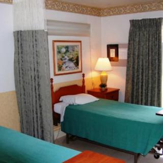 A cozy hotel room with twin beds and warm lighting.