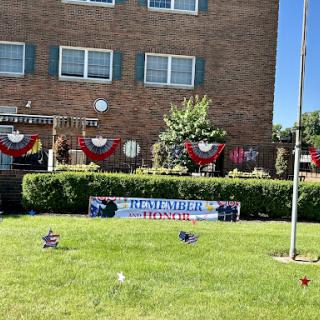 A beautifully decorated building showcasing patriotic elements and a well-maintained lawn.