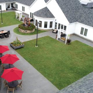 Aerial view of a well-maintained courtyard with red umbrellas and outdoor seating.