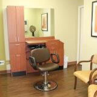 A well-lit hair salon interior with a styling chair and mirror.
