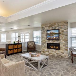 A modern living room featuring a stone fireplace and cozy seating.