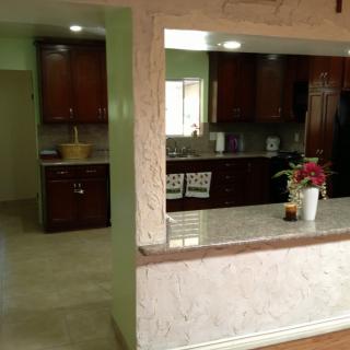 Modern kitchen with dark wood cabinets and a granite countertop in an open-plan design.