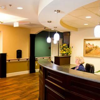 A well-lit reception area with a modern desk and comfortable seating.