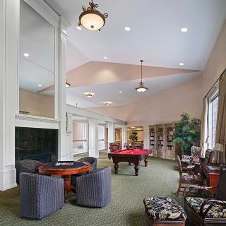 A spacious game room with a pool table and comfortable seating.