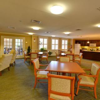 Spacious dining and seating area with a kitchen in the background.