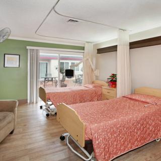 A clean and well-organized hospital room with two patient beds and a calming atmosphere.