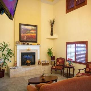 A cozy living room featuring a fireplace, artwork, and comfortable seating.