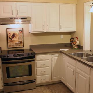 A modern kitchen with stainless steel appliances and white cabinets.