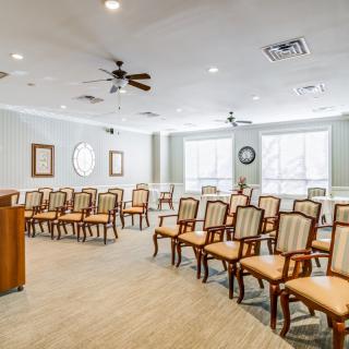 A well-lit meeting room with rows of chairs arranged for a conference.