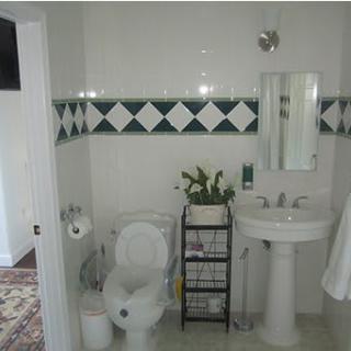 A clean bathroom with a sink, toilet, and decorative tiles.