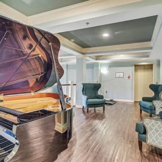 A modern lobby featuring a grand piano and comfortable seating with elegant interior design.
