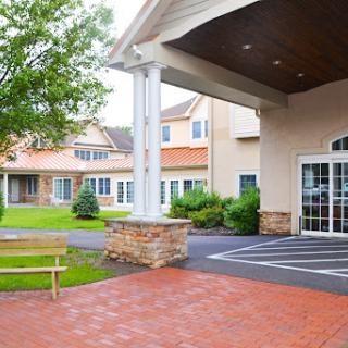 A welcoming entrance of a residential facility surrounded by greenery.