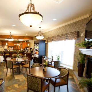 A cozy and modern dining area featuring round tables, comfortable chairs, and elegant lighting fixtures.