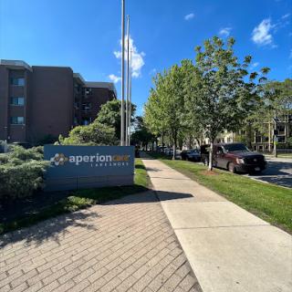 A view of the apartment complex entrance along a well-maintained sidewalk.