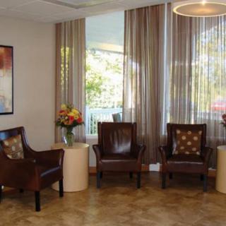 A cozy waiting area with leather chairs, soft lighting, and decorative flowers.