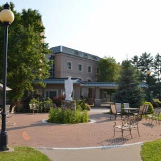 A serene outdoor space featuring a well-maintained garden and seating area, framed by a beautiful building.