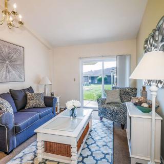 A cozy living room with a blue sofa, patterned armchair, and bright decor.