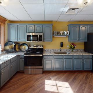 A cozy kitchen with blue cabinets and modern appliances.