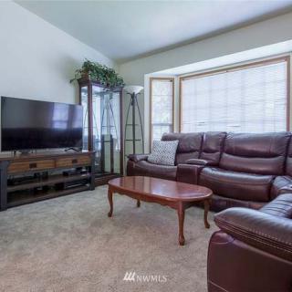 A cozy living room with a leather sofa, coffee table, and television.