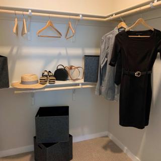 A neatly organized closet with clothes, hats, and accessories.