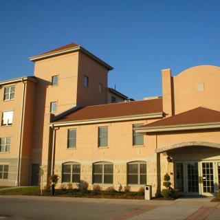 A sunlit exterior view of a hotel building.