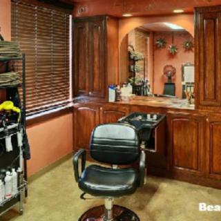 A cozy barber shop interior with a styling chair, mirror, and wooden cabinets.