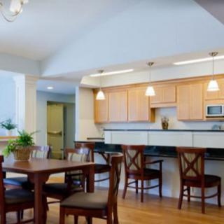 A modern kitchen and dining area featuring wooden furniture and pendant lighting.