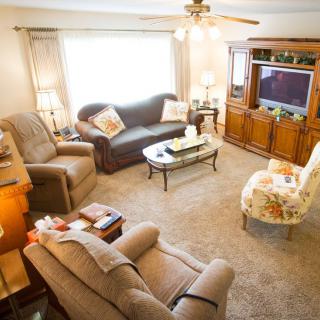 A cozy living room with comfortable seating and a TV entertainment center.