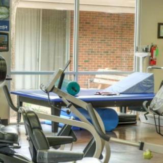 A well-equipped gym with exercise machines and a ping pong table.